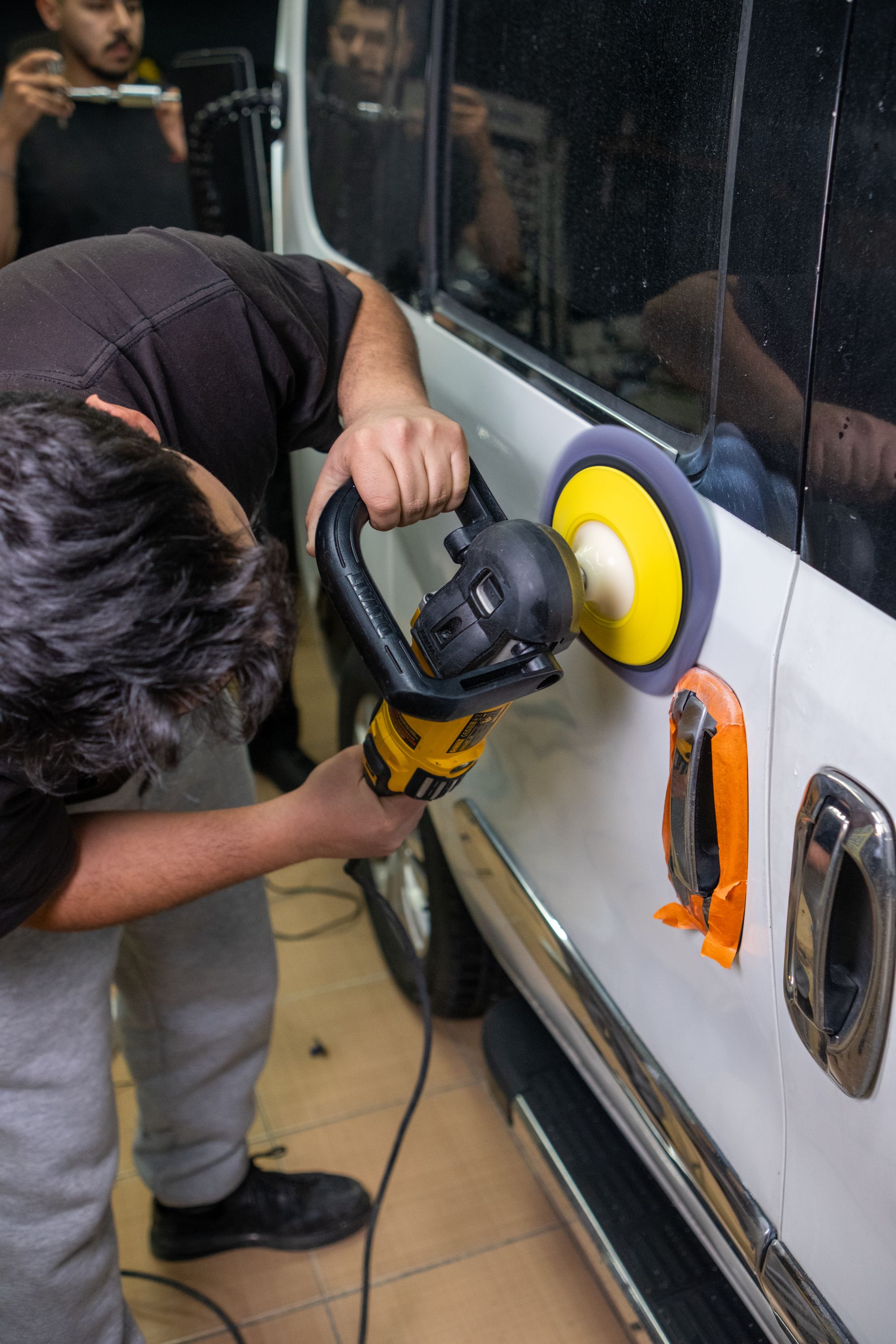 Technician polishing a black vehicle